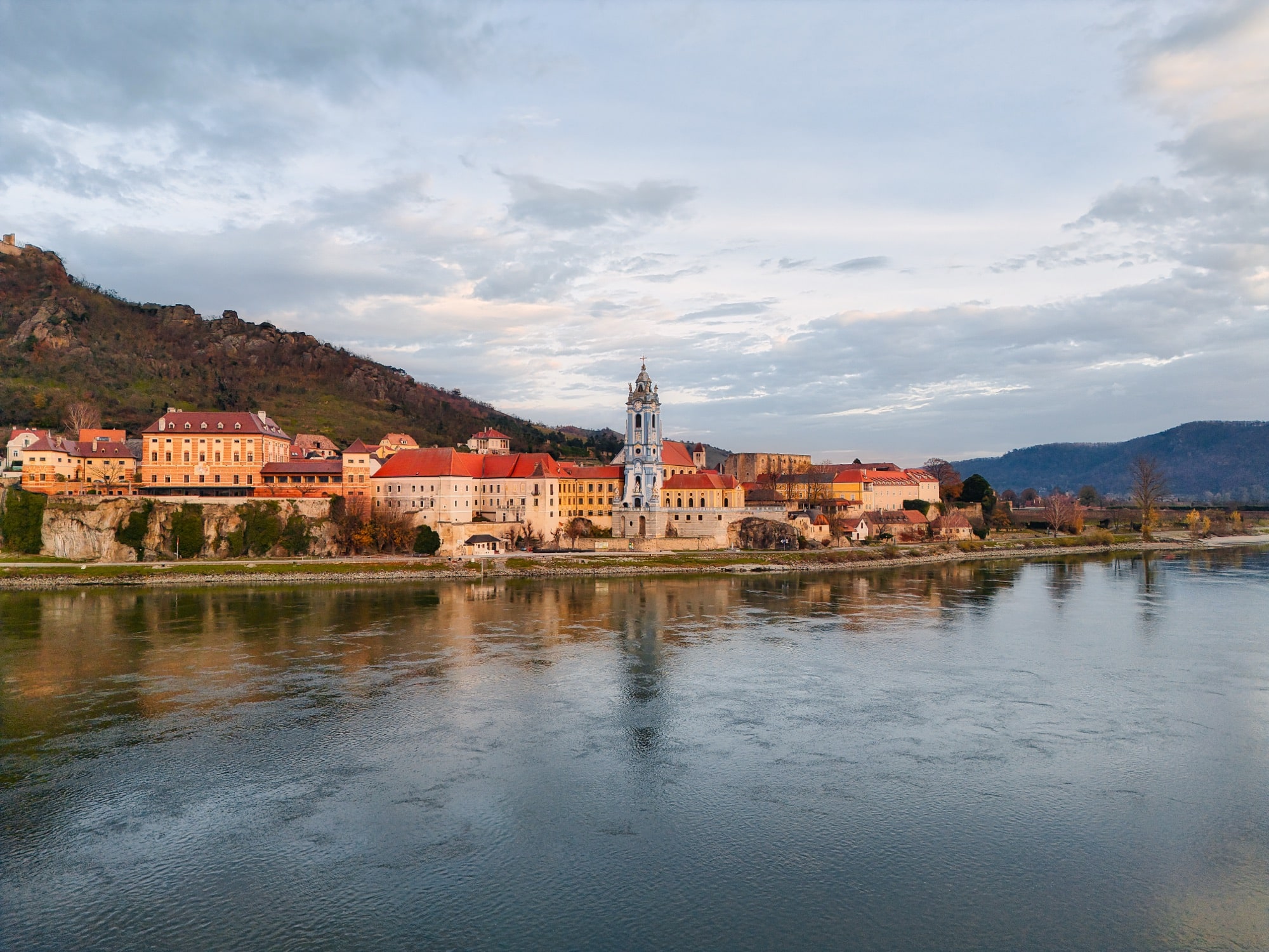 Duernstein abbey and its terraced old town glowing above the Danube at dawn.