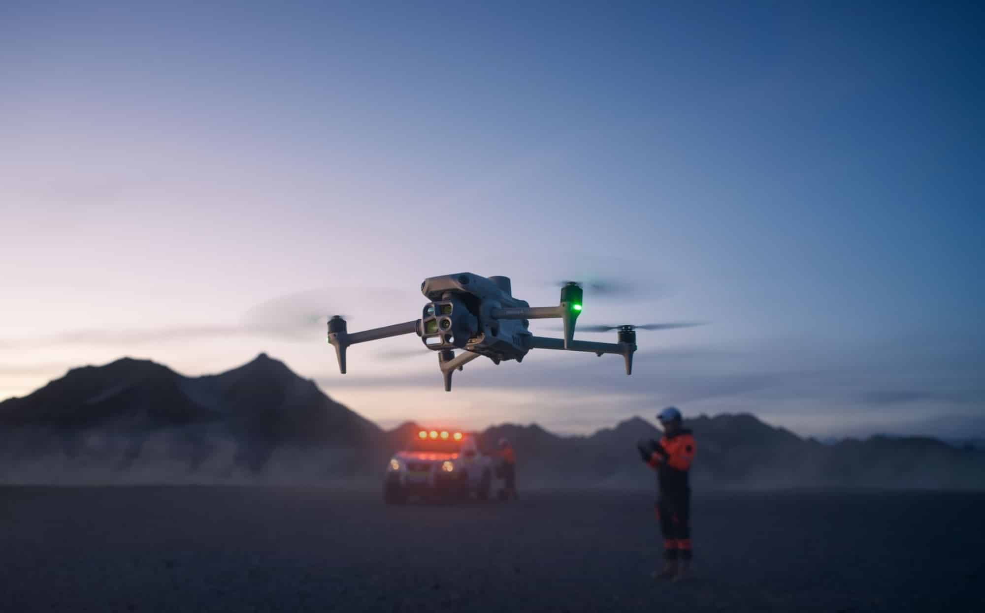 Matrice 4 flying at dusk as a responder and light-bar vehicle wait below.