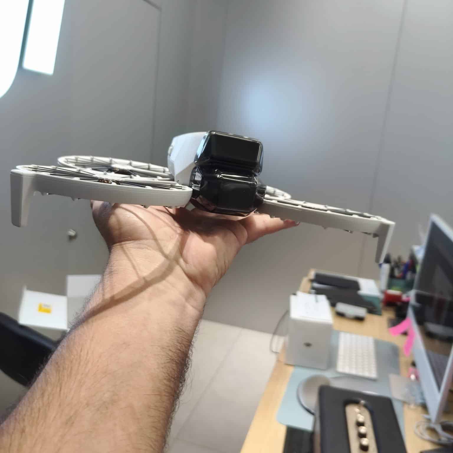 Hand holding the Flip folded flat in an office, arms tucked against the body.