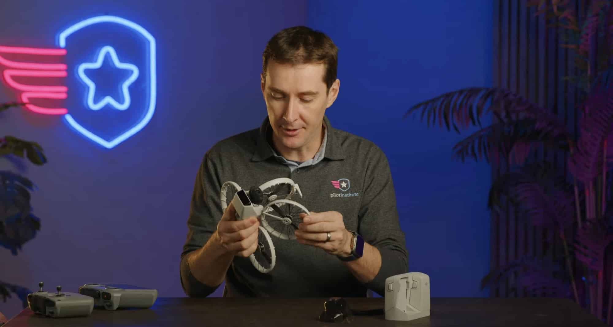 Presenter holding the DJI Flip in a studio with a Pilot Institute neon sign.