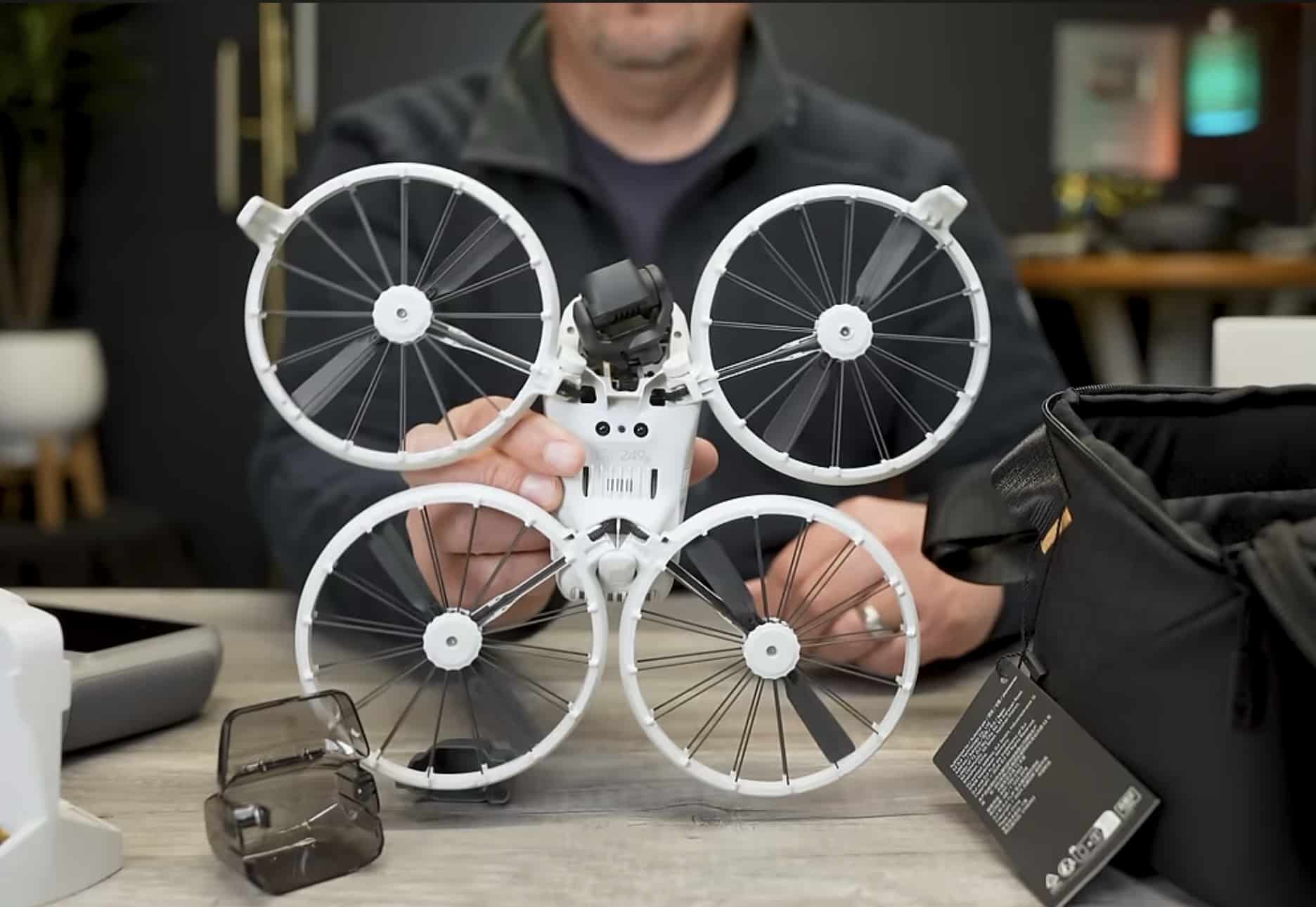 Hands hold the Flip upright to show its underside and folded arms.