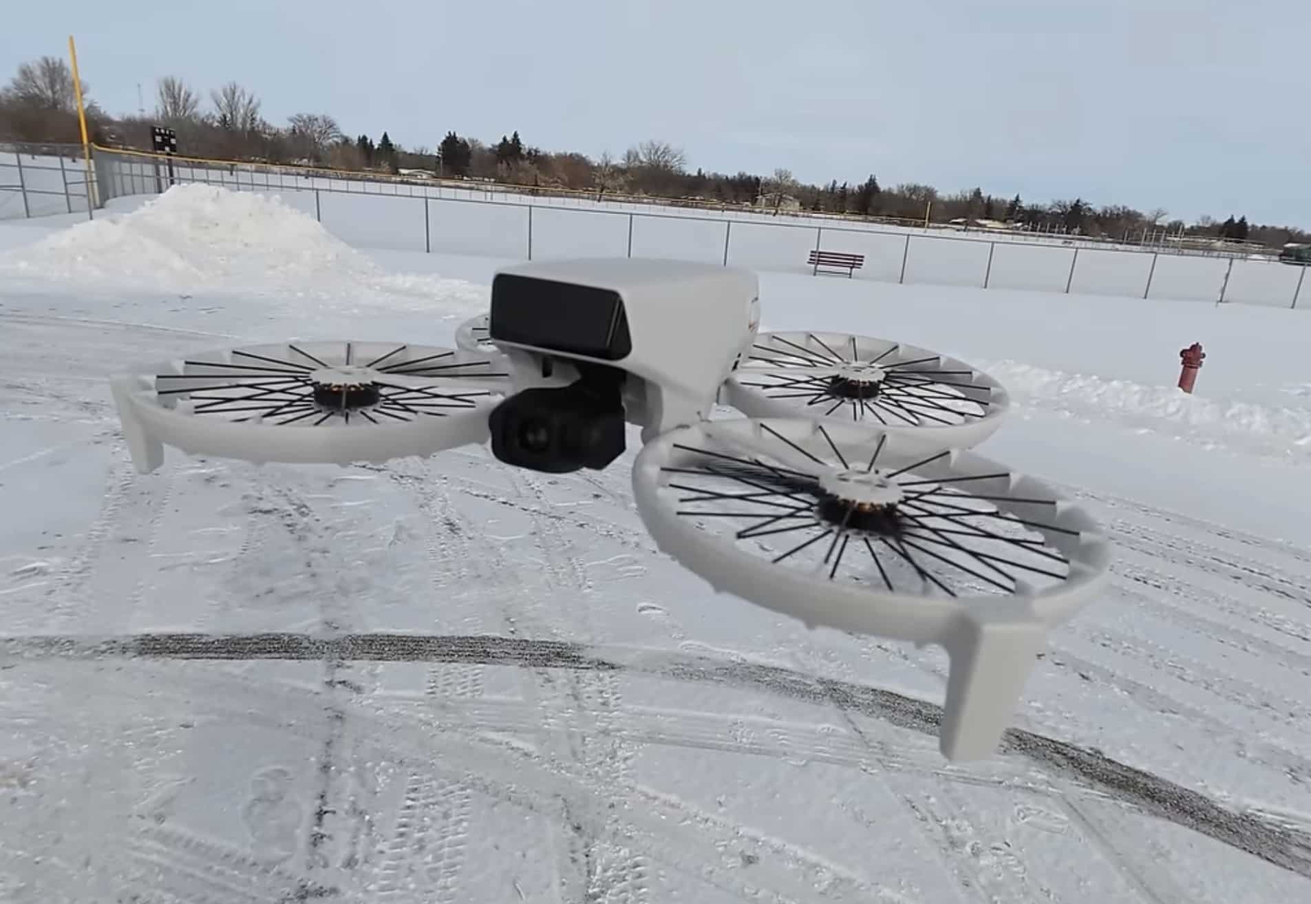 Side view of the white Flip resting on packed snow in an open lot.