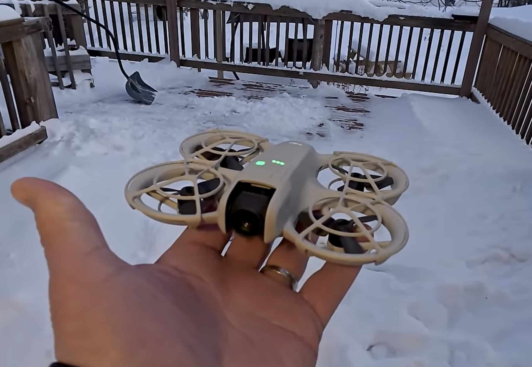 The Flip balances on an open palm above a snow-covered wooden deck.