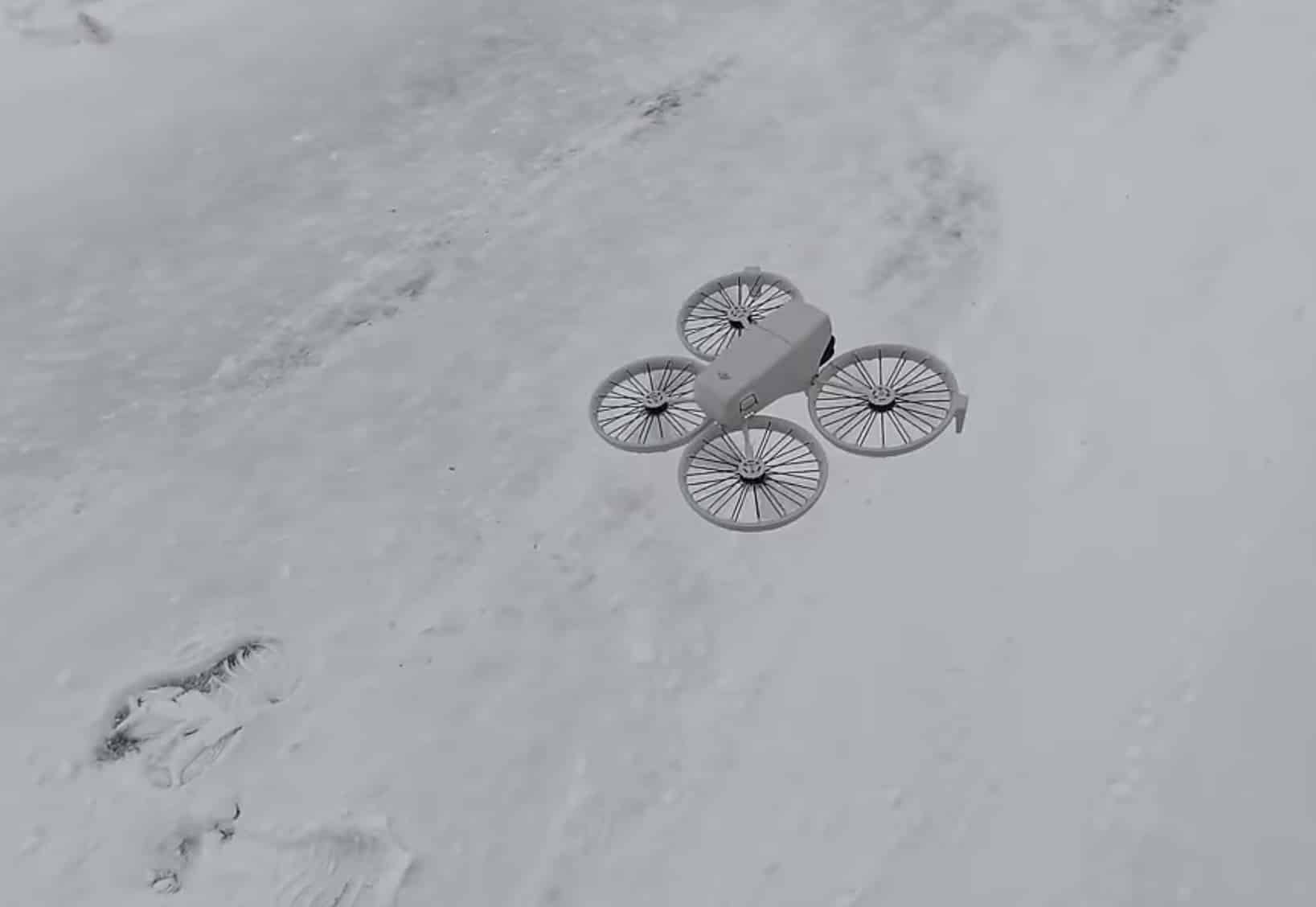 Overhead frame of the Flip hovering above snow marked with boot prints.