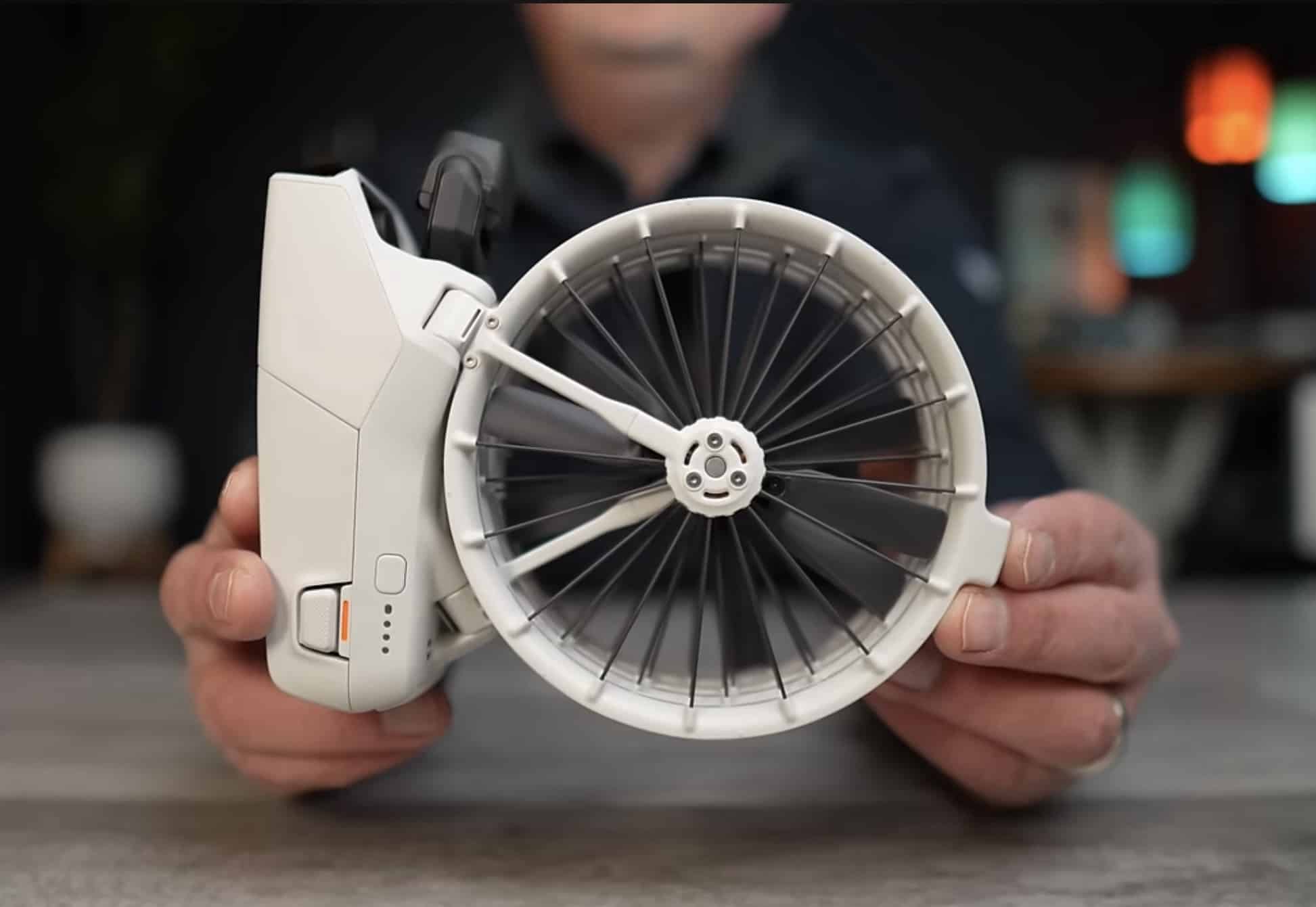 Hands turn the Flip so one bladed propeller cage faces the camera.