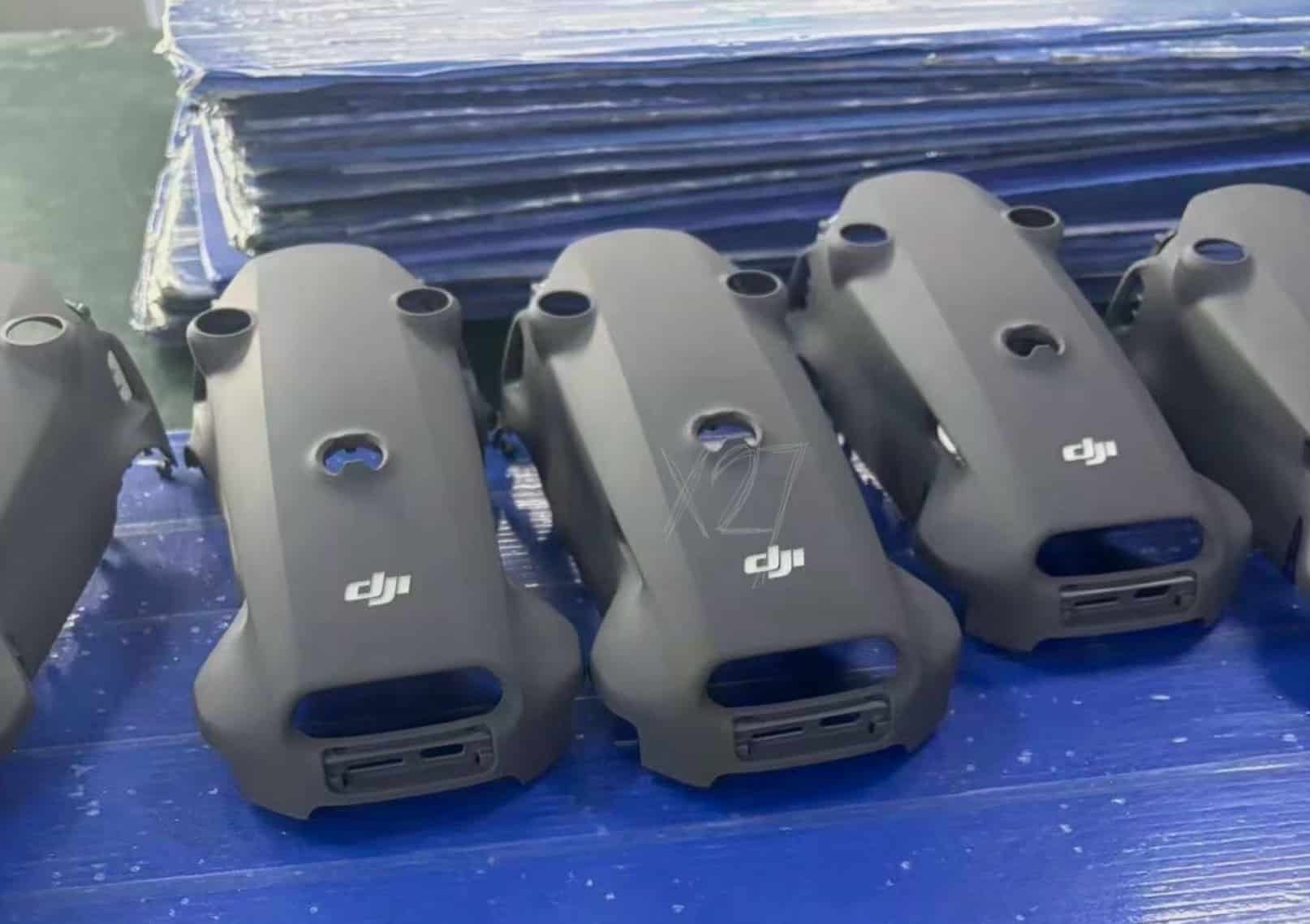 Rows of gray Mavic top covers stacked on a blue production tray.