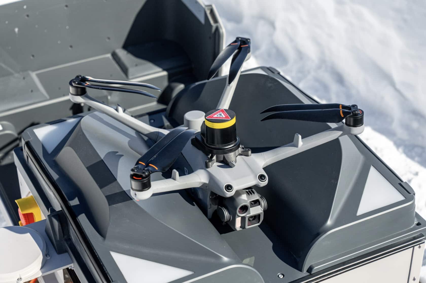 Quadcopter with a LiDAR dome landing on a dock mounted atop a vehicle.