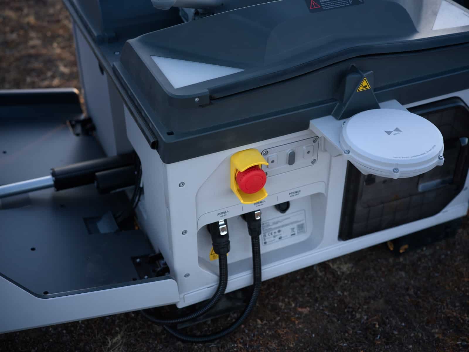 Close-up of the dock yellow emergency stop switch, power cabling and antenna dome.