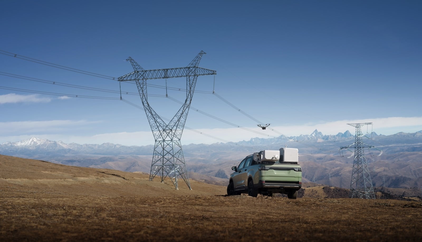 Green pickup parked under a lattice pylon with the dock mounted in its bed.
