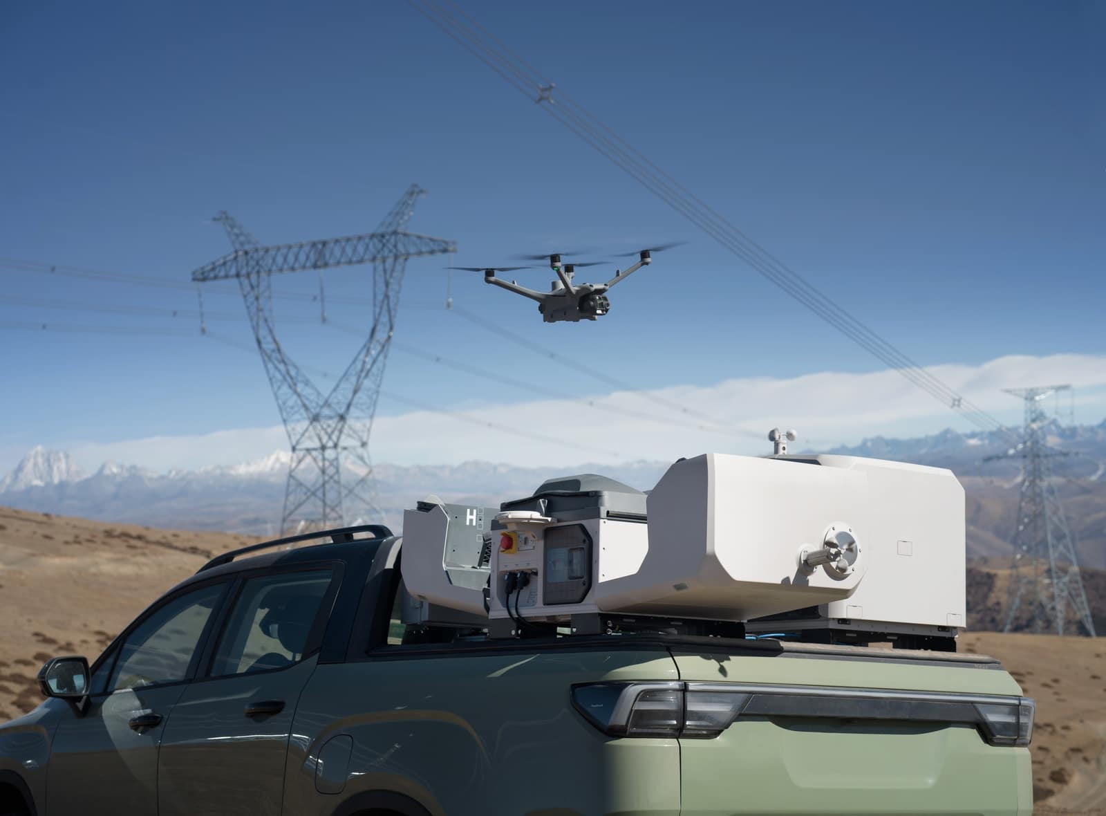 Truck-mounted dock in the foreground as the drone passes the power line.