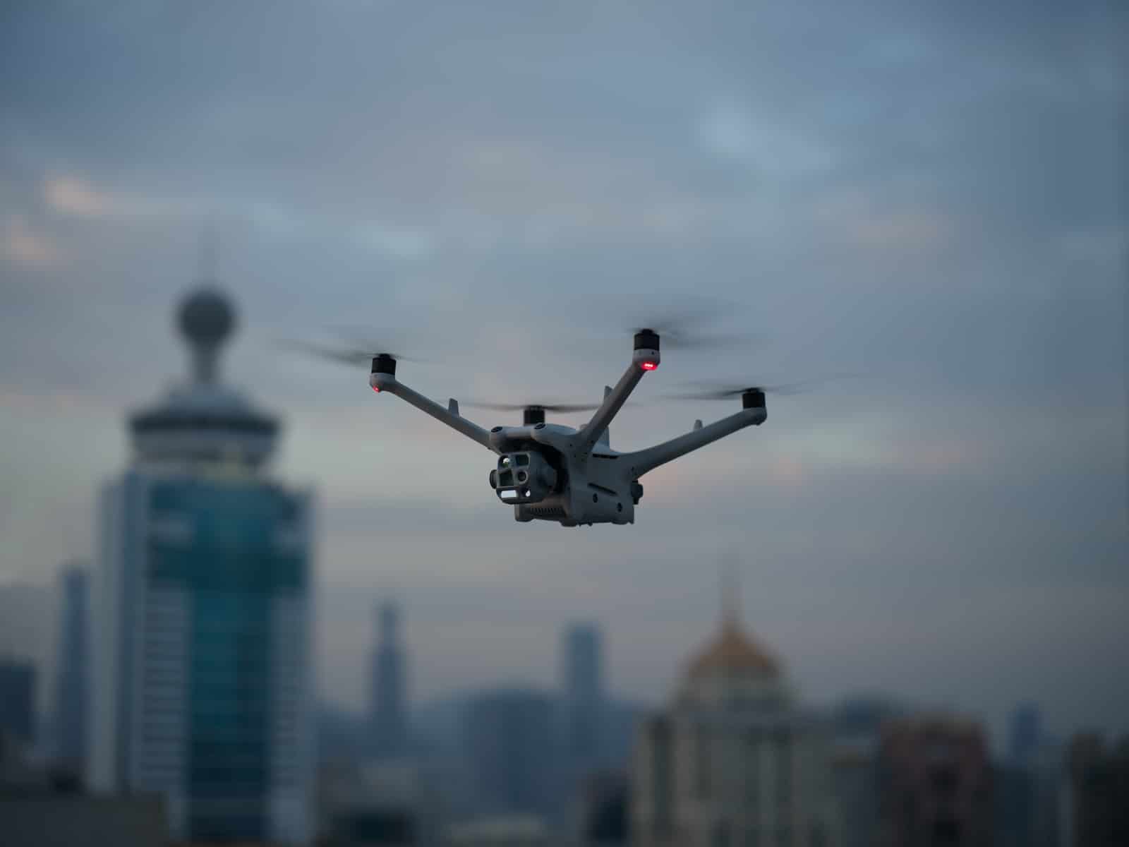Drone flying above a hazy downtown skyline with a distinctive domed tower.