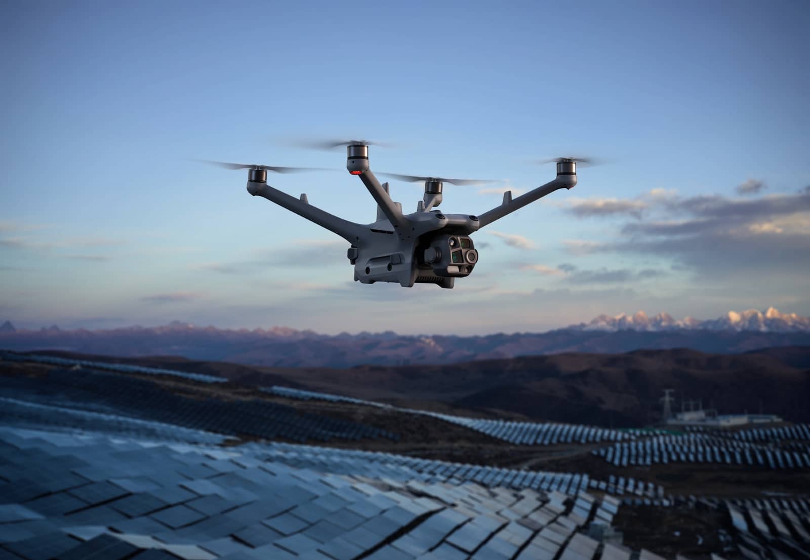 Drone banking above a huge photovoltaic array with mountains on the horizon.