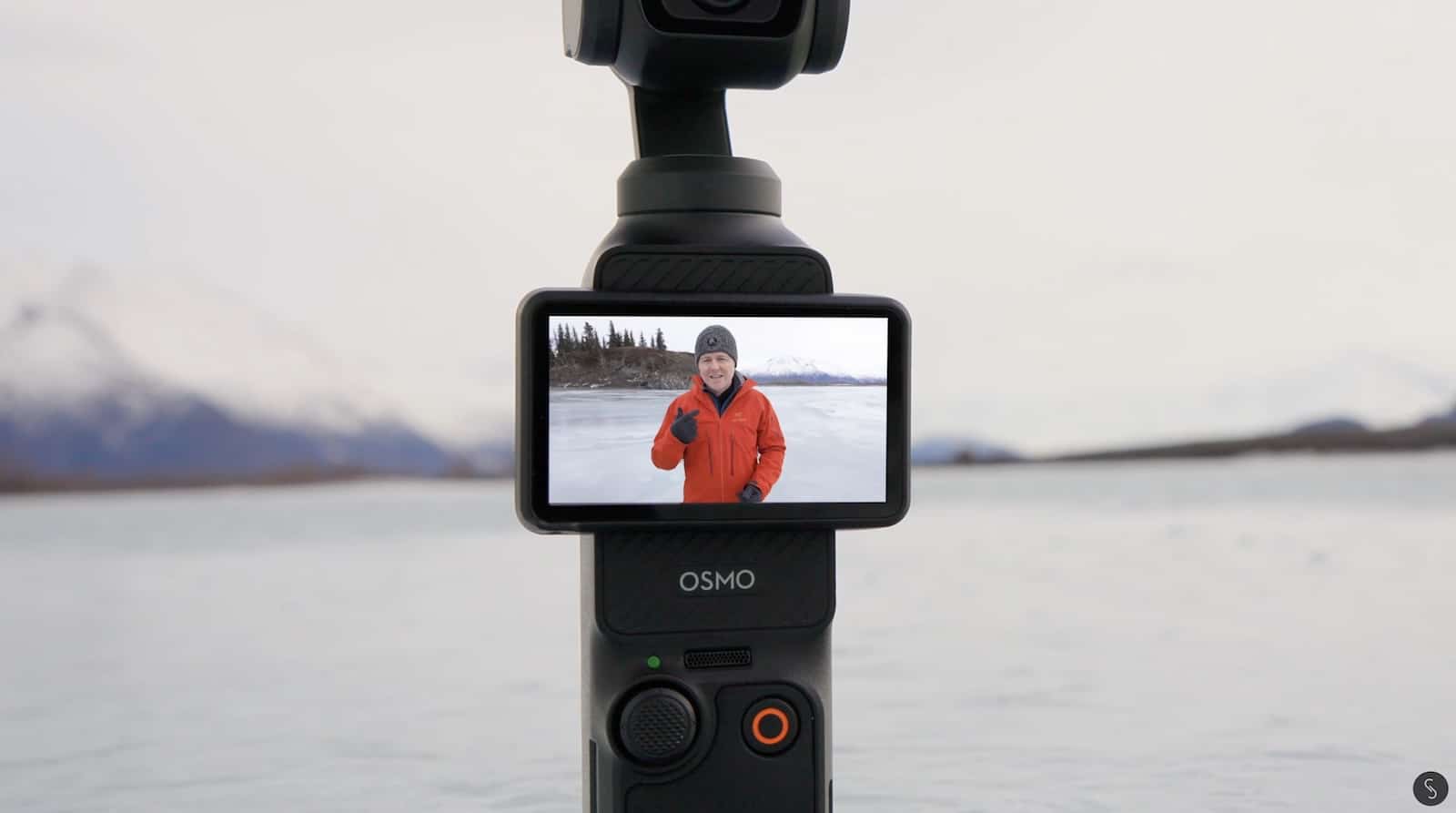 Pocket 3 screen framing the presenter in an orange jacket on the ice.