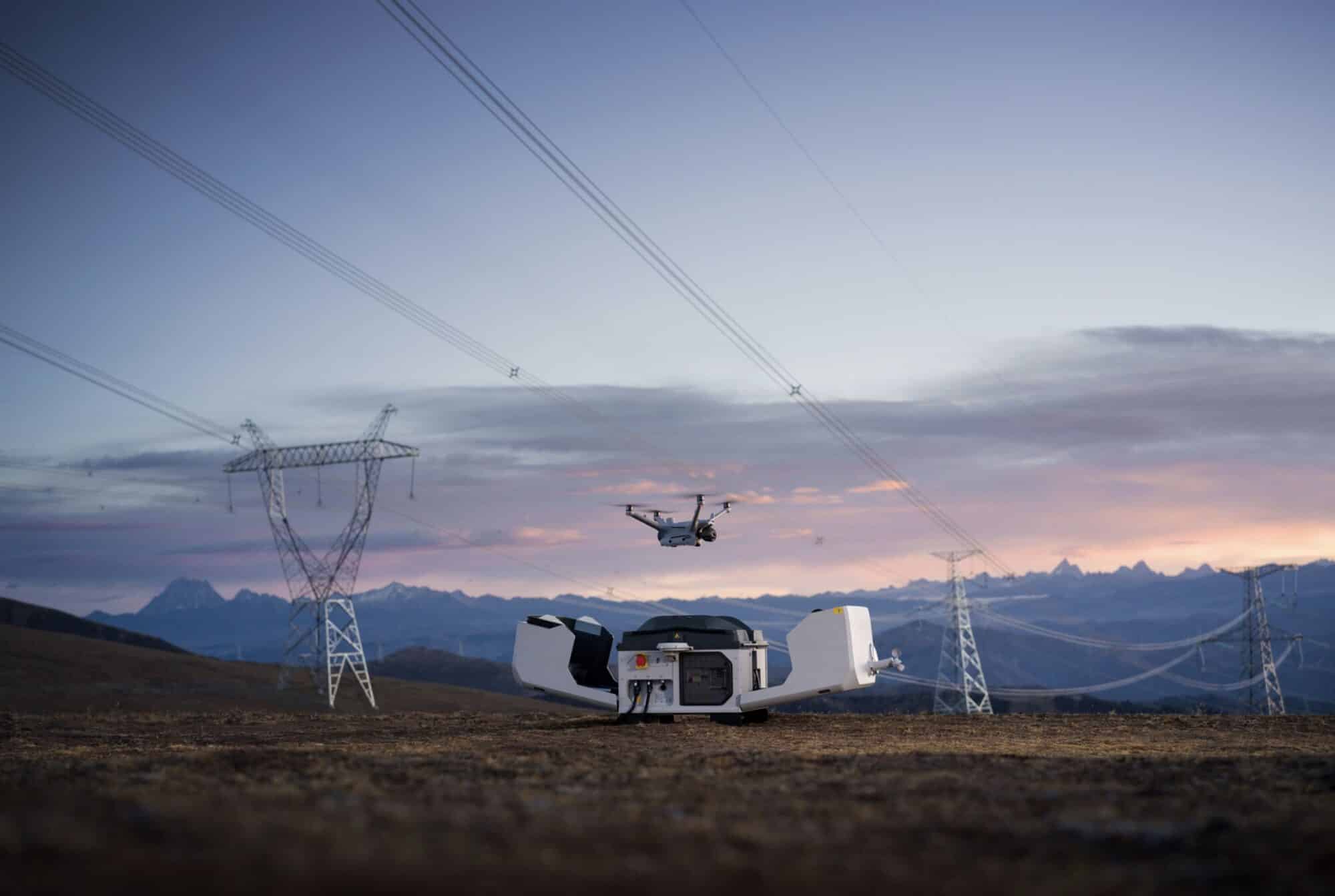 Dock open on grassland as the drone rises toward the lines at dusk.