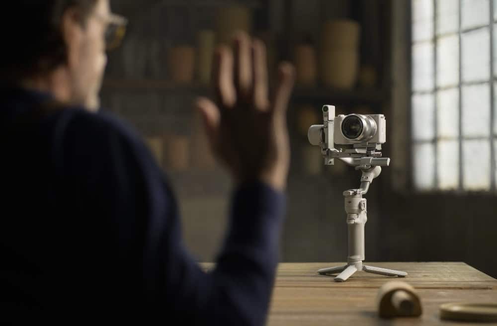 A raised palm signals the gimbal on a table, demonstrating gesture control.