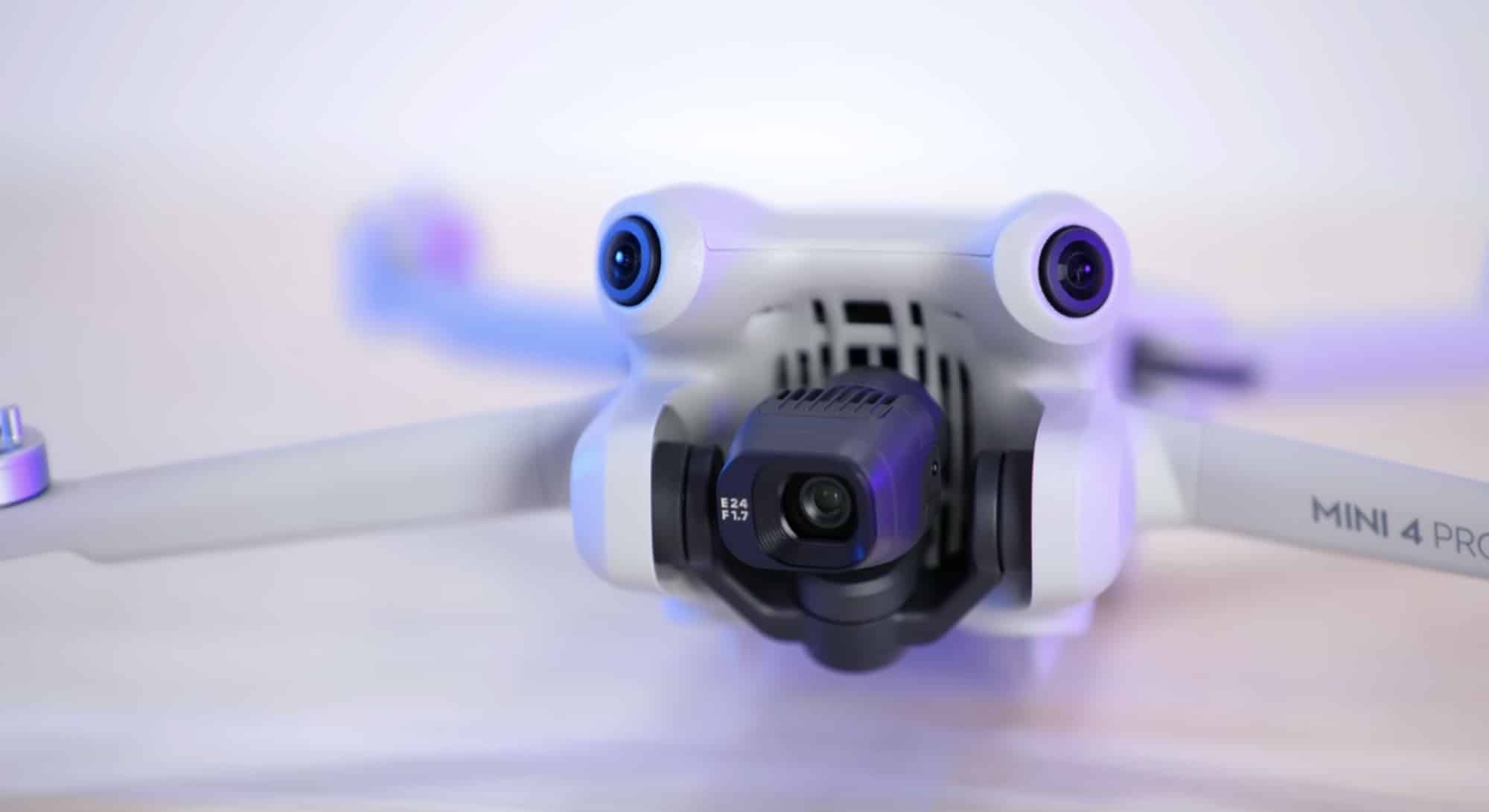 Close-up of the Mini 4 Pro with its gimbal and forward sensors glowing blue.