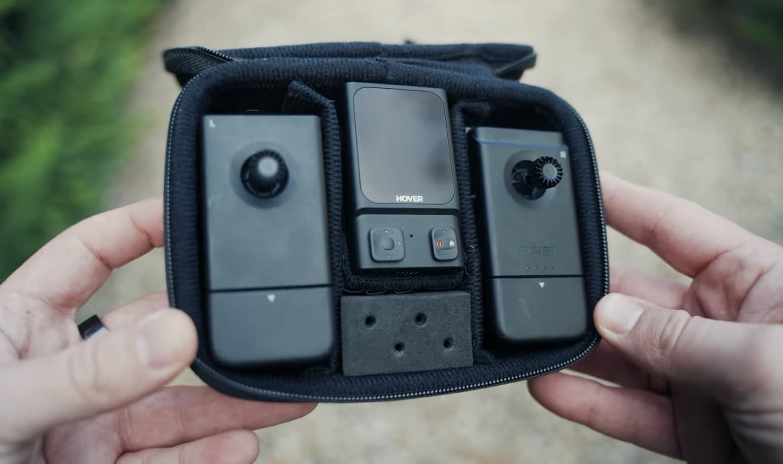 Hands open a zip case holding the beacon and its two detachable joysticks.