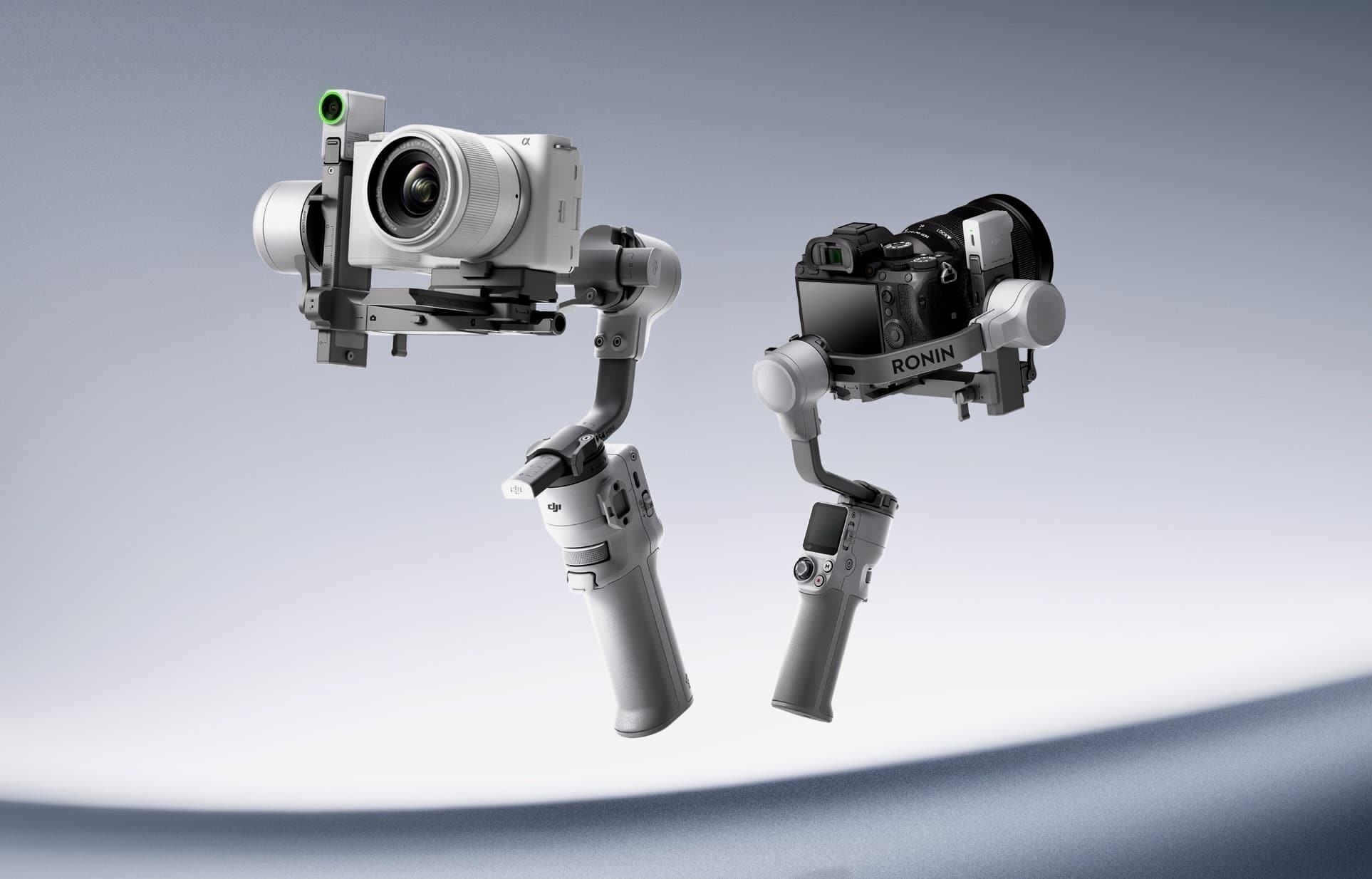 Two RS 4 Mini gimbals, white and black, float side by side with cameras mounted.