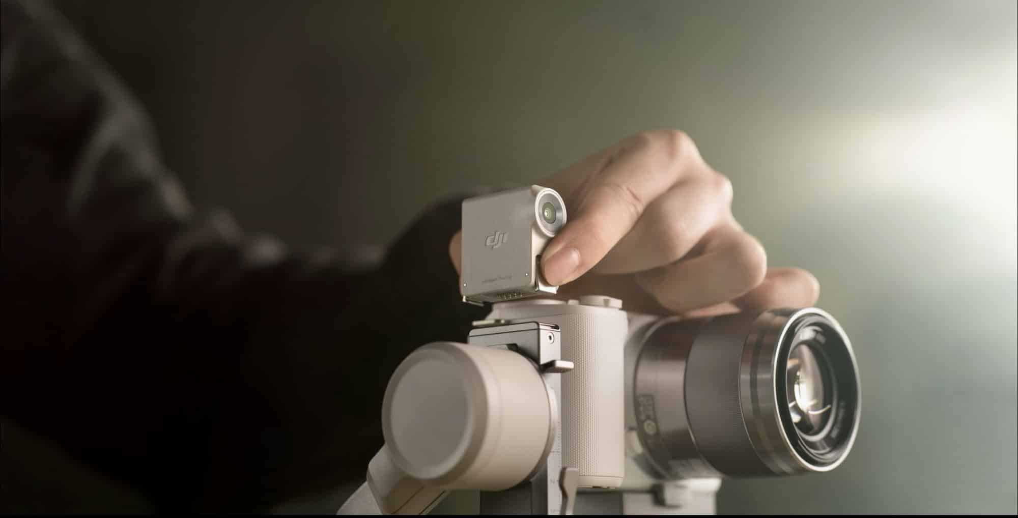 A hand snaps the magnetic tracking module onto the gimbal above a camera.