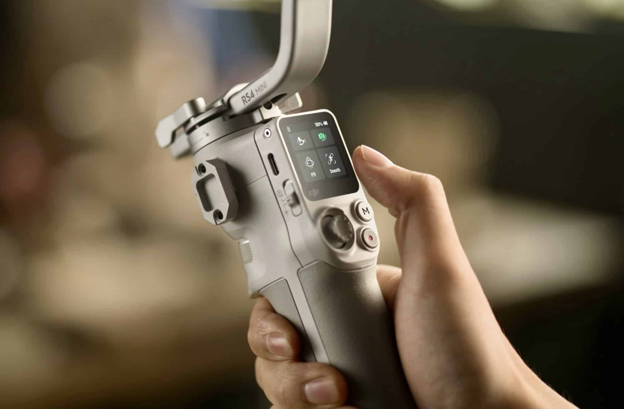 A thumb works the touchscreen and control dial on the gimbal handle.