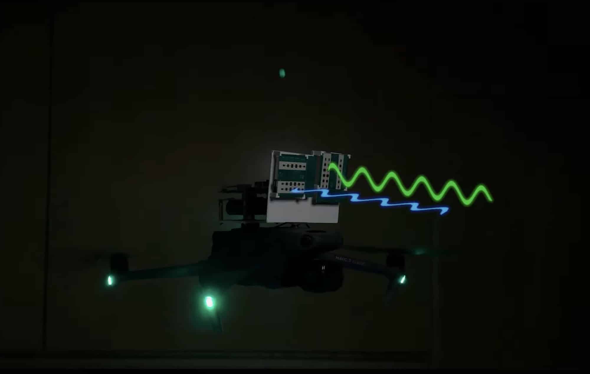 Test quadcopter flies in a dark room with radio waves drawn as coloured ripples.