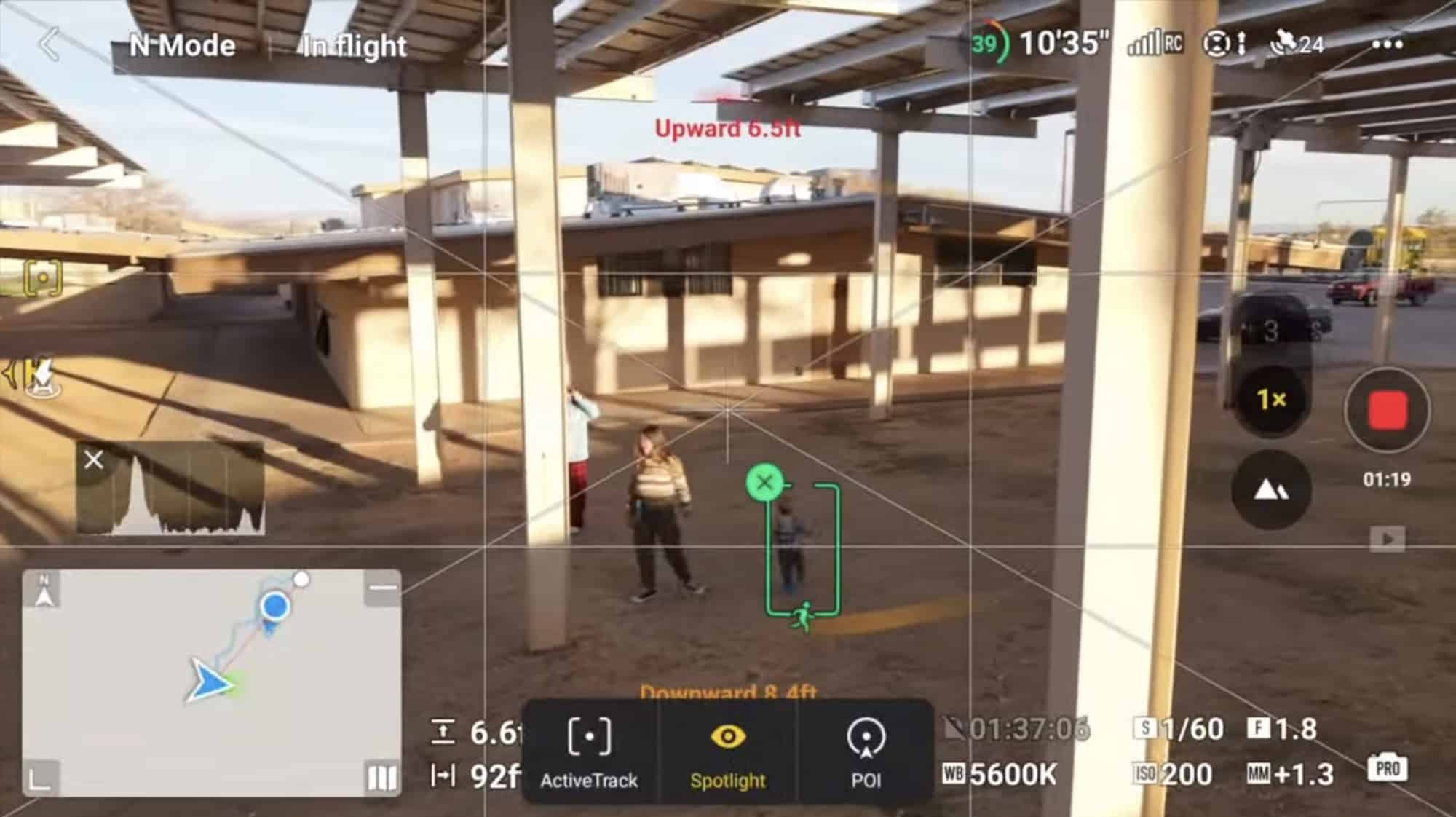 DJI Fly screen with ActiveTrack boxing a person under a concrete overpass.
