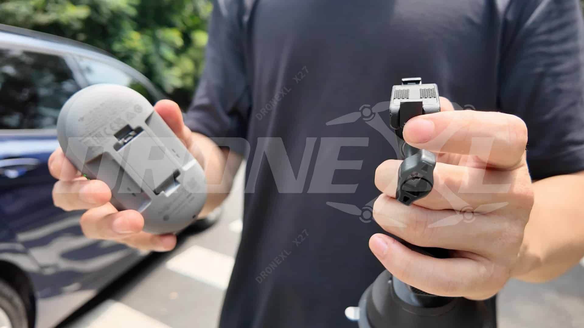 A person holds the rounded beacon in one hand and a mount clip in the other.