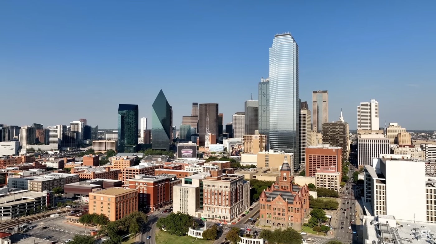 Aerial view of a downtown skyline of glass towers above brick warehouse blocks.