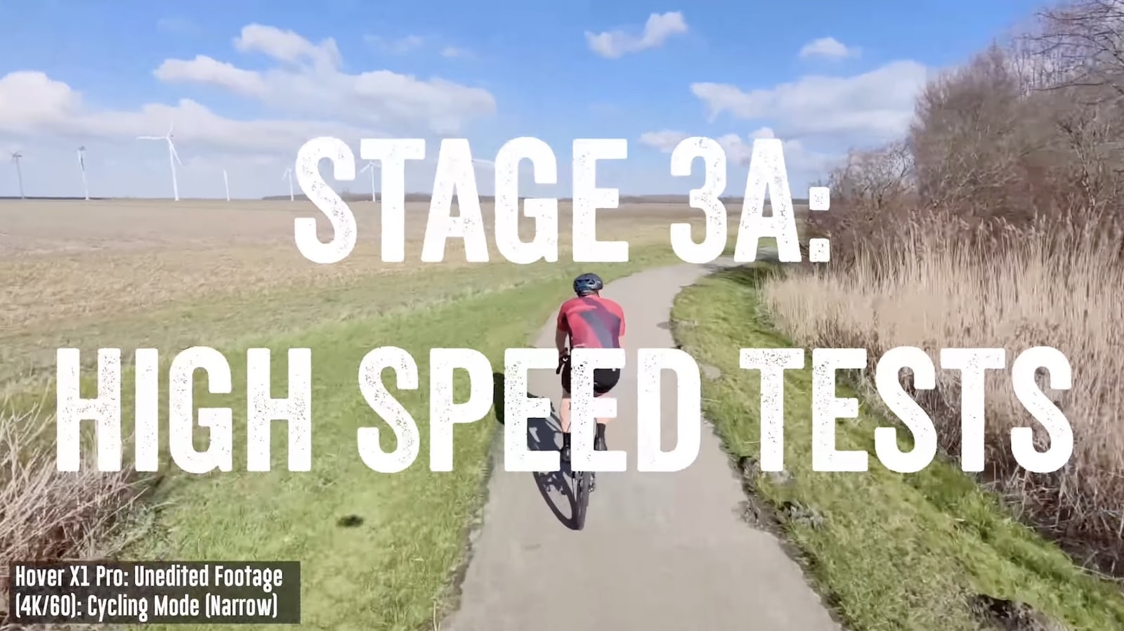 Stage 3A card with the cyclist accelerating past fields and distant wind turbines.
