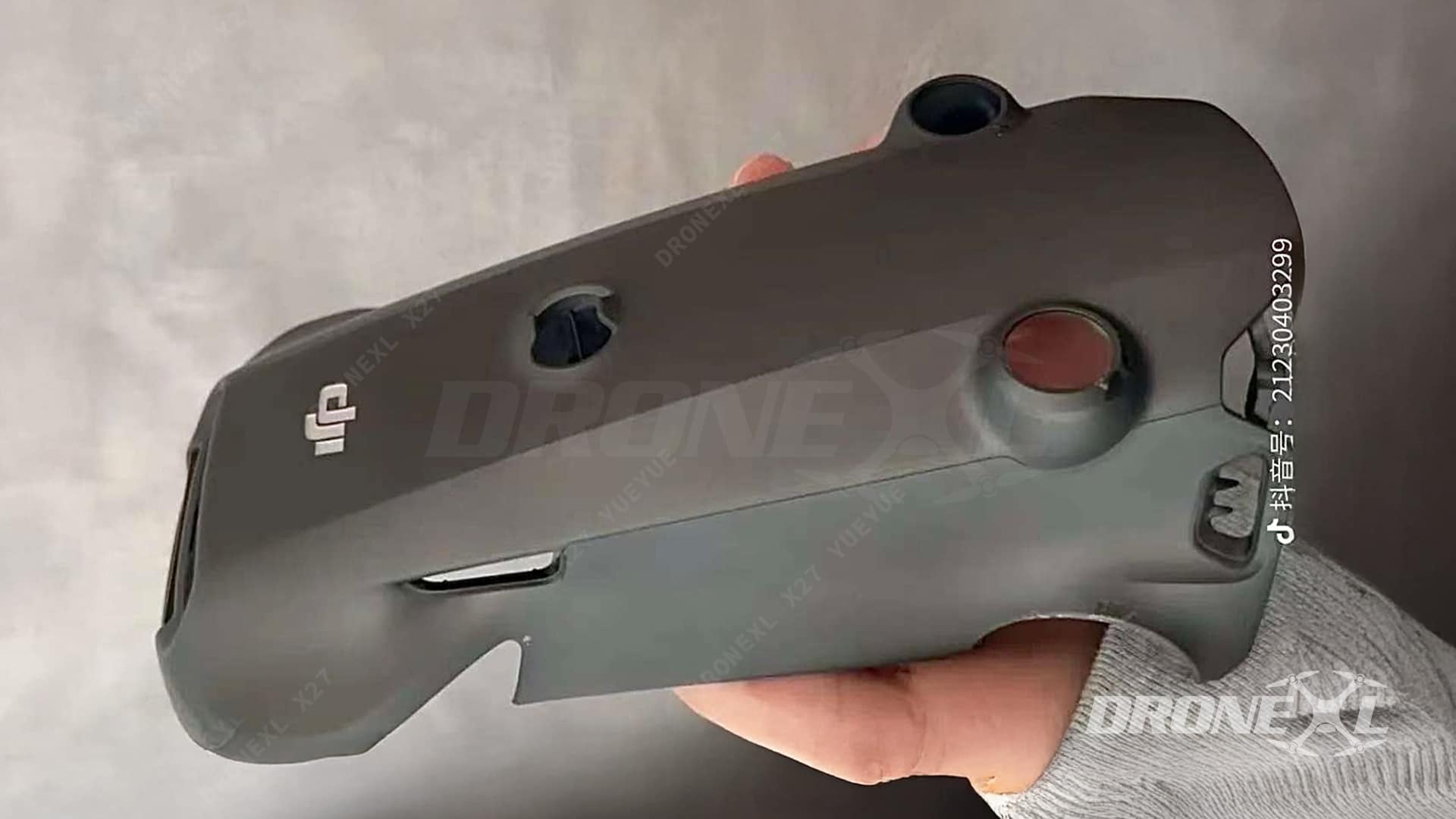 Hand holding a bare Mavic 4 Pro top shell with sensor cutouts.