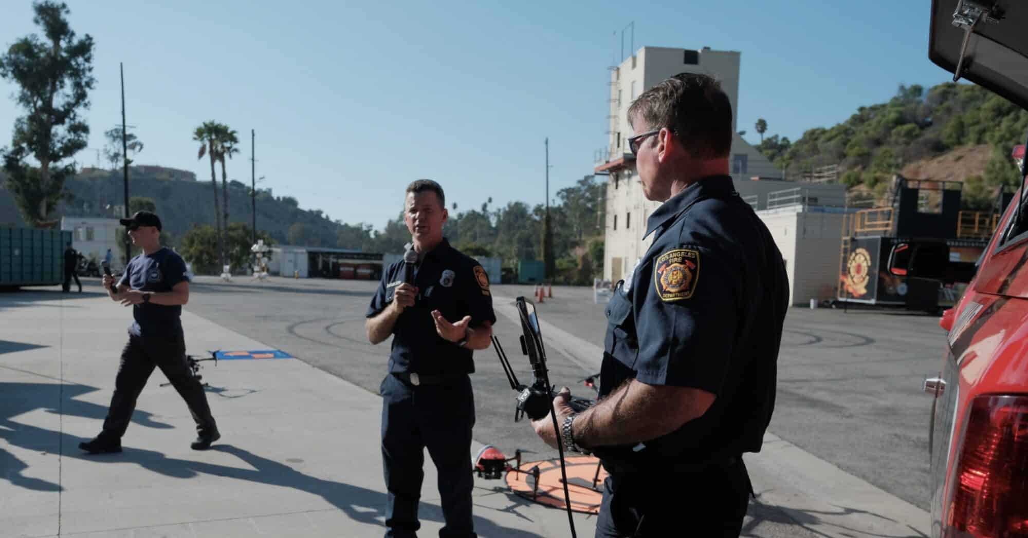 Firefighters gather around a drone on the tarmac at a Los Angeles fire training facility.