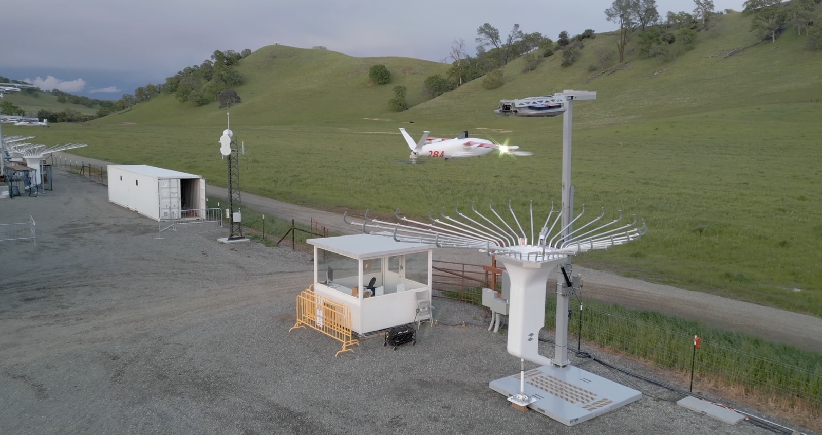 Aircraft descends toward a docking mast at the hillside operations site.