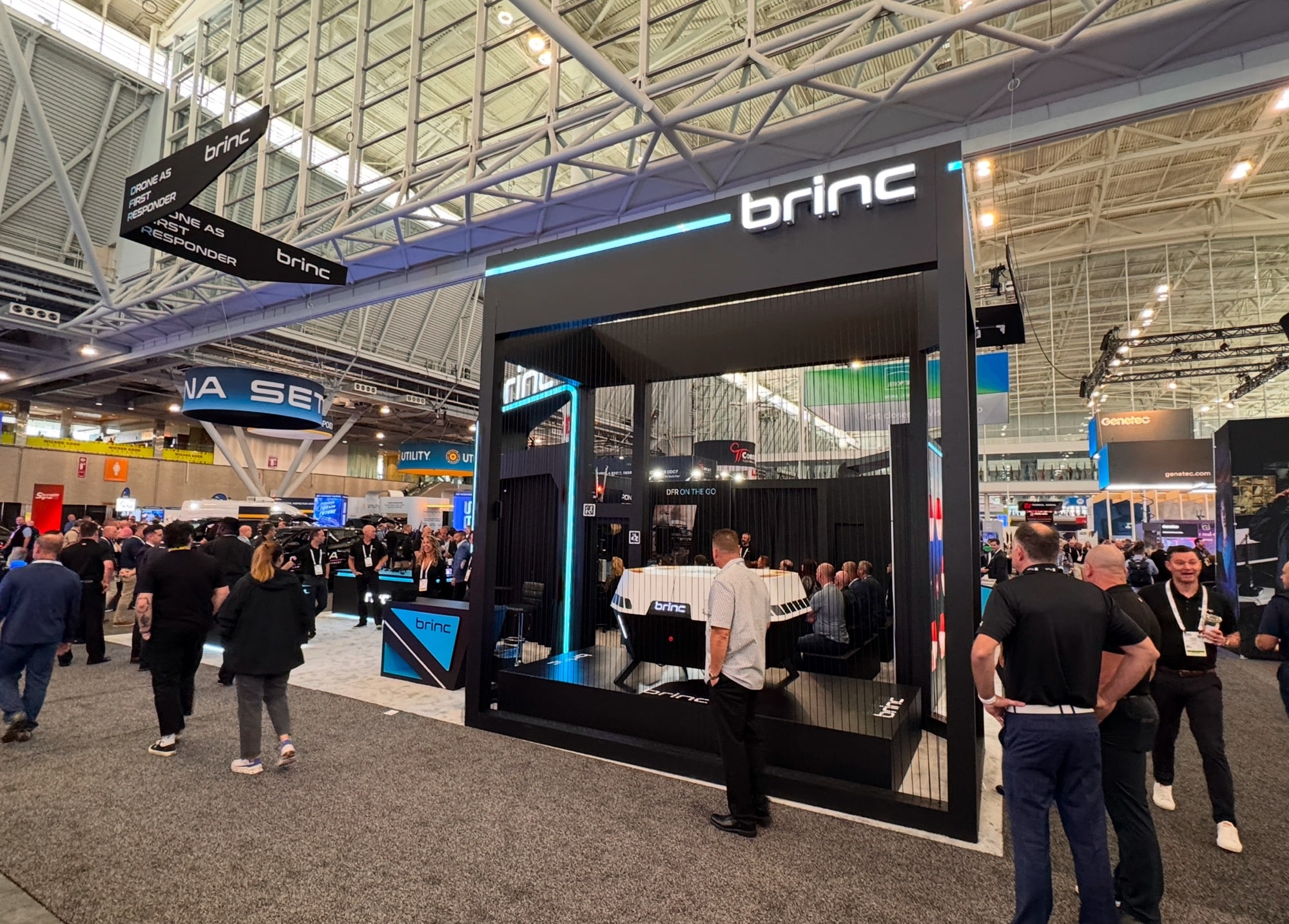 BRINC trade show booth with attendees walking past on the expo floor.