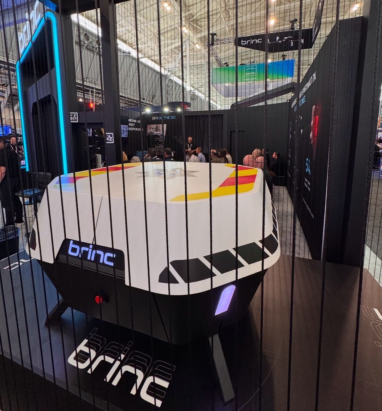 Large BRINC drone dock displayed behind vertical bars at the booth.