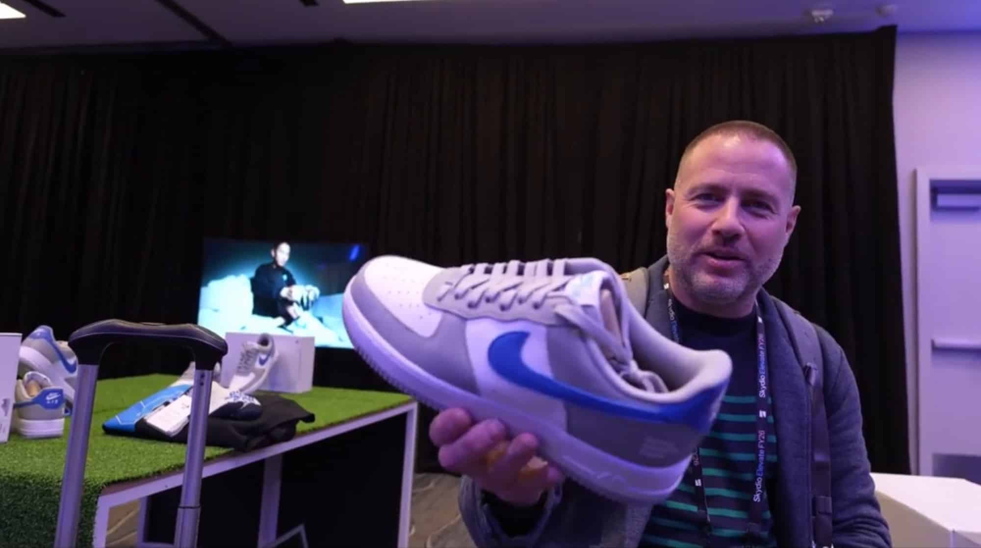Attendee holding up a co-branded sneaker in front of the swag display.