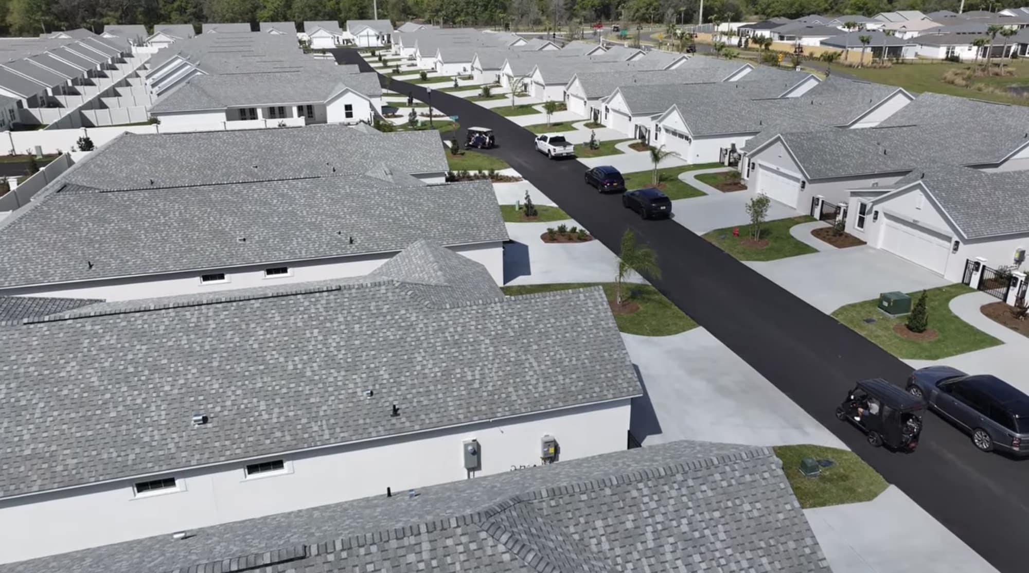 Aerial view of newly built homes lining a street in a planned community.