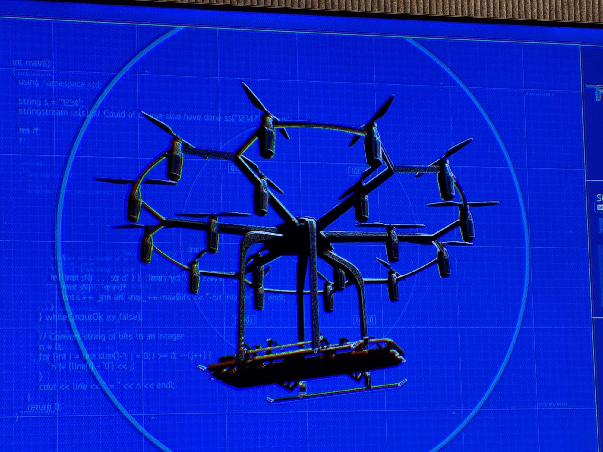 A many-rotor emergency response aircraft rendered over blue engineering code on screen.