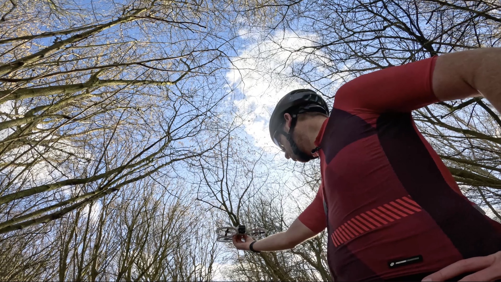 Looking up as the rider reaches into bare branches to free the drone.