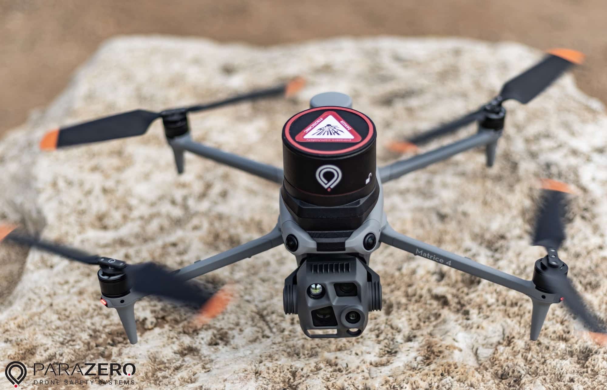 SafeAir M4 canister and its red warning label sit atop a drone on rock.