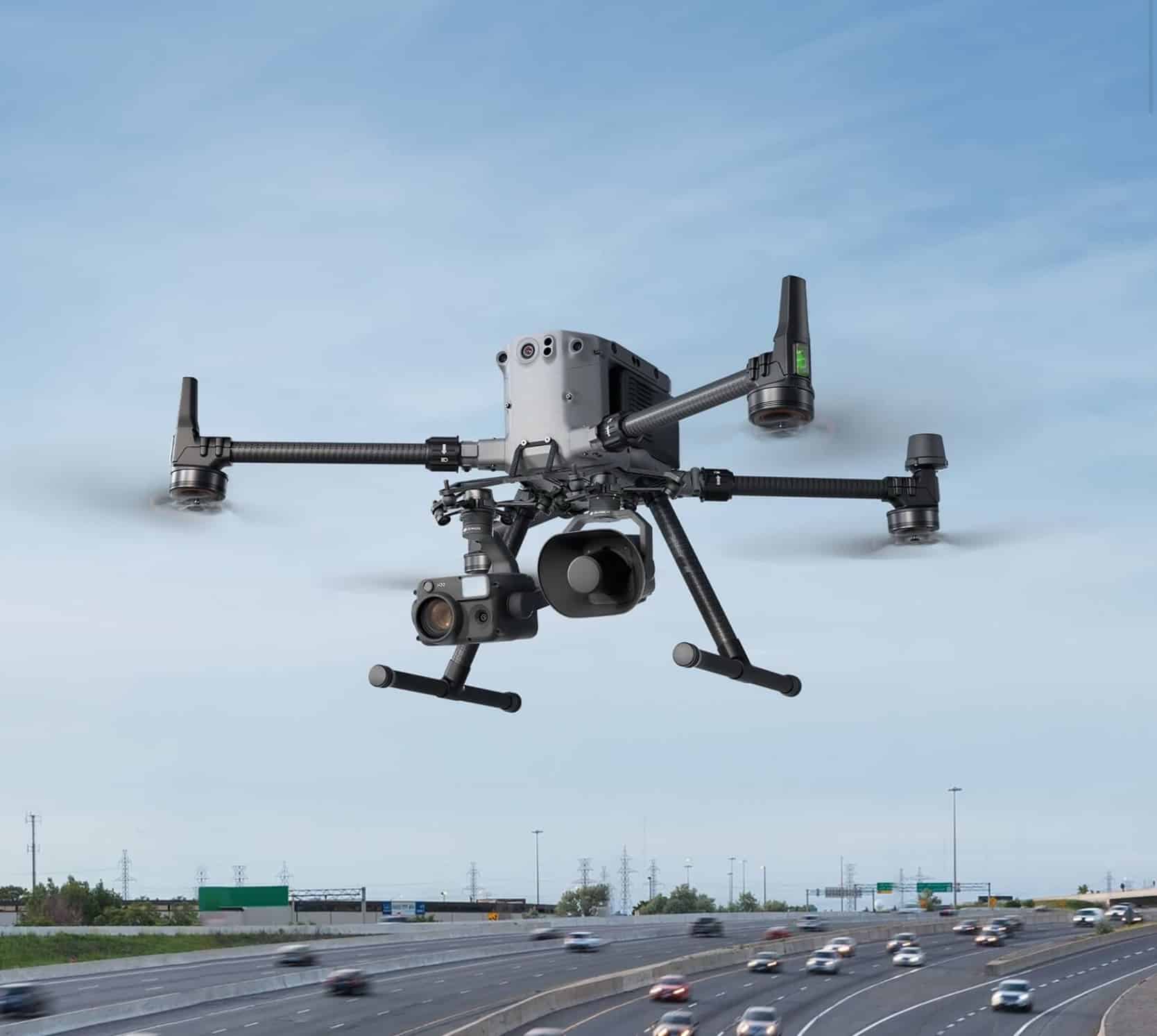 Matrice drone carrying a speaker payload above a busy multilane highway.