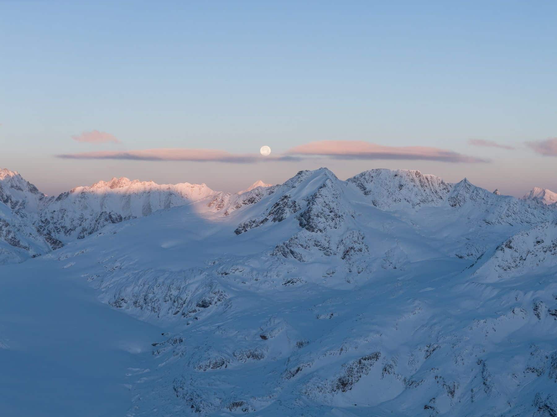 Moonrise over a snow-covered range framed at 70mm equivalent.