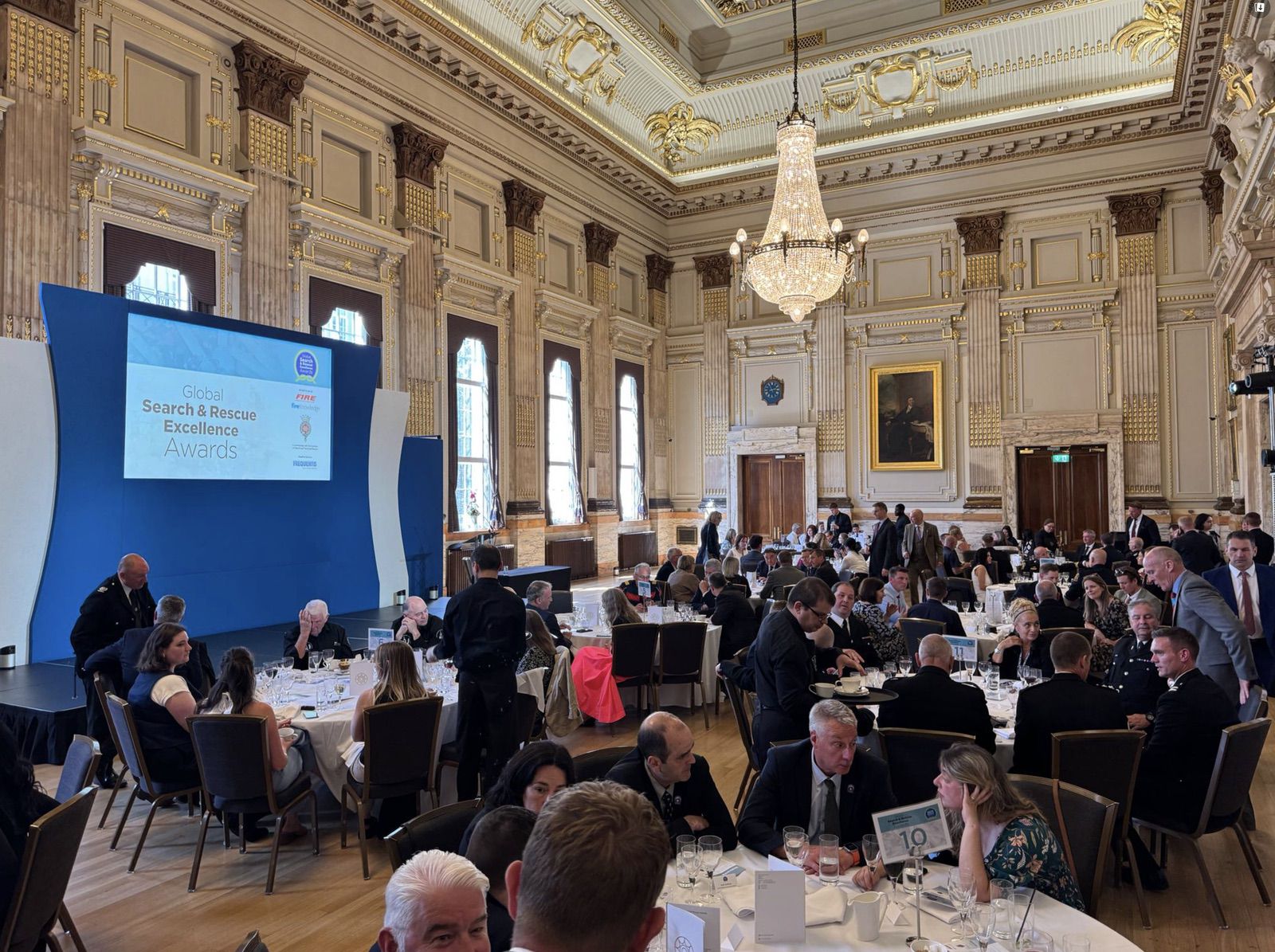 Wide view of the banquet hall with the awards banner beside the seated audience.
