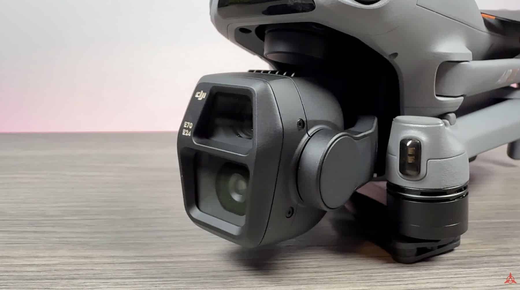 Close-up of the dual-camera gimbal against a pink sunset over calm water.
