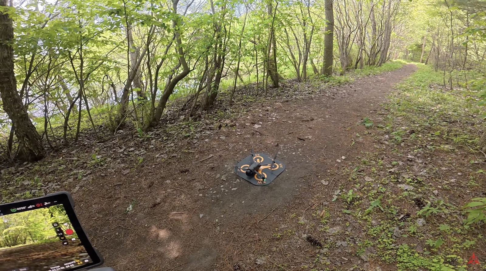 The Mavic 4 Pro sits on the dirt path after landing itself in the woods.