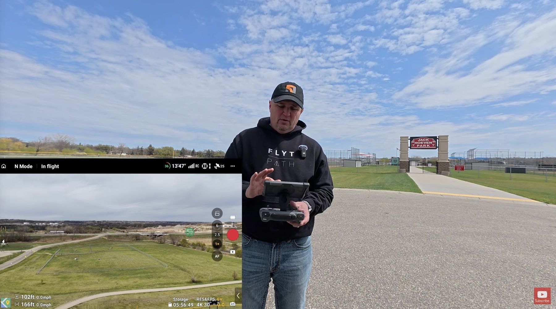 The reviewer stands on an airfield apron with the flight app view inset.