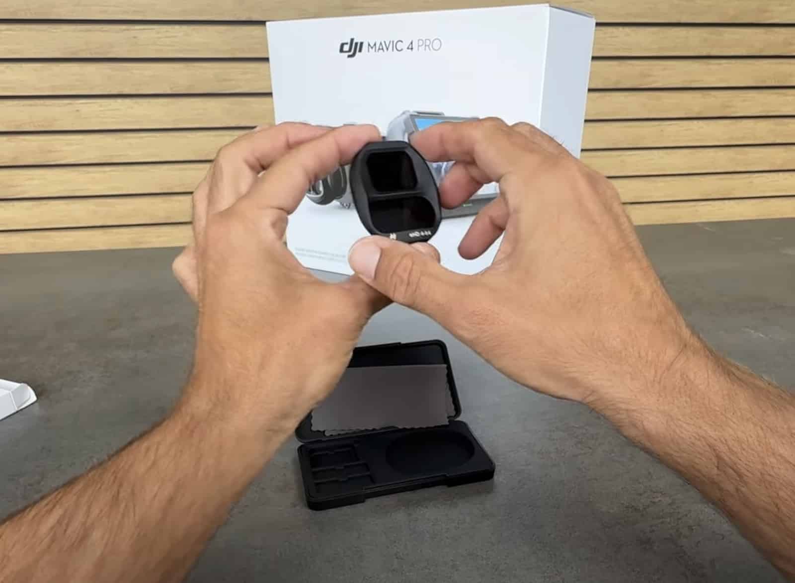 Hands hold a snap-on neutral density filter in front of the retail box.