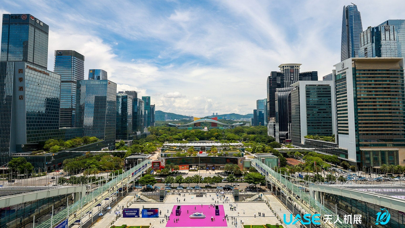 Glass towers rise above a busy pedestrian plaza in central Shenzhen.