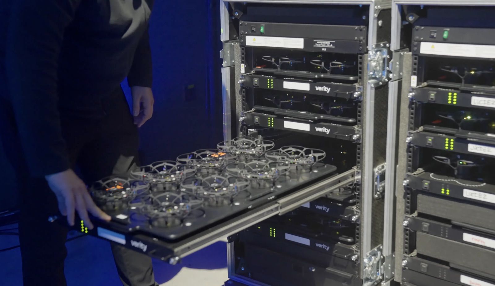 Technician sliding a tray of Lucie micro drones into a rack of flight cases.