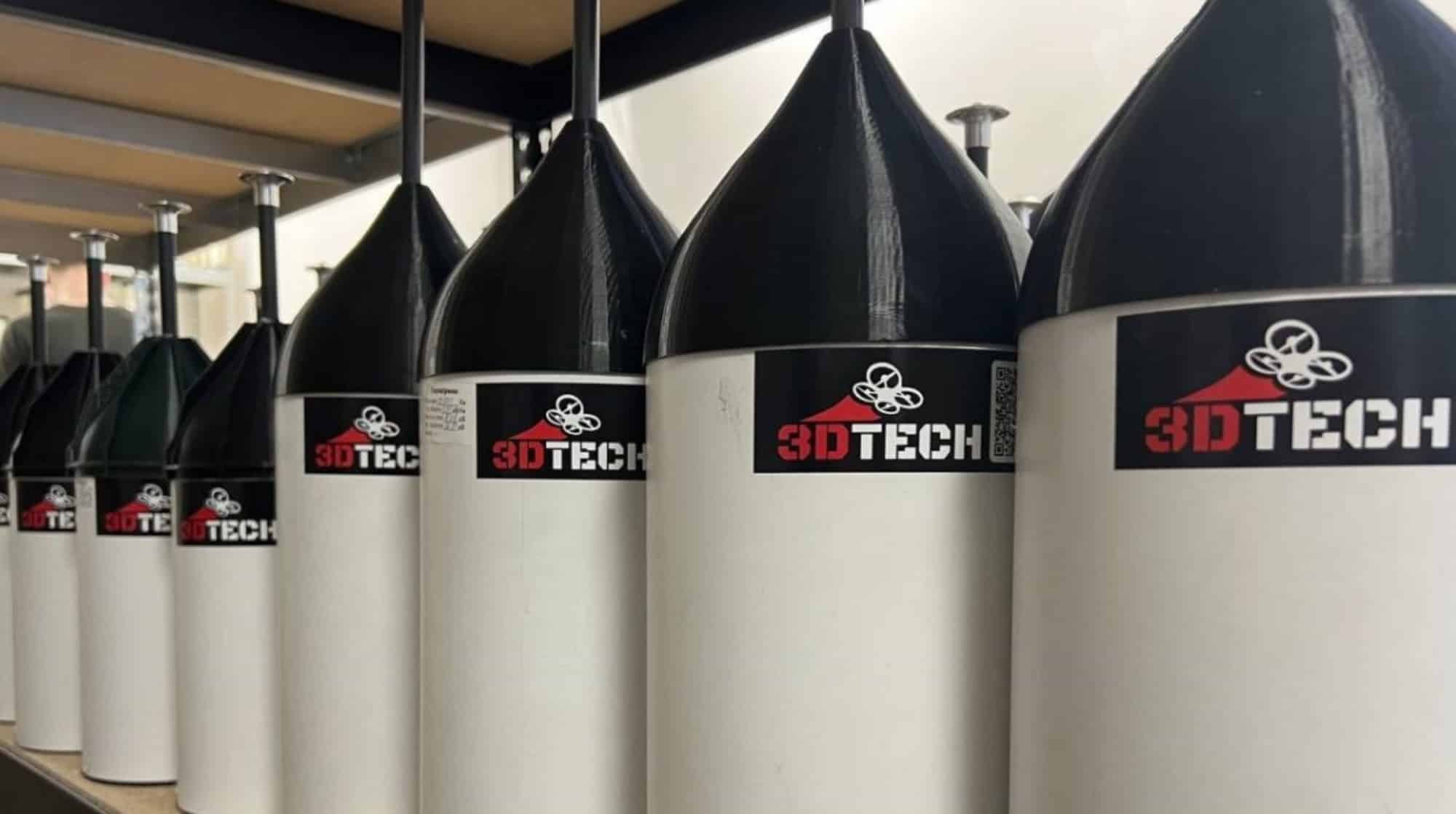 Row of black-tipped fiber-optic spool canisters branded 3DTECH on a shelf.