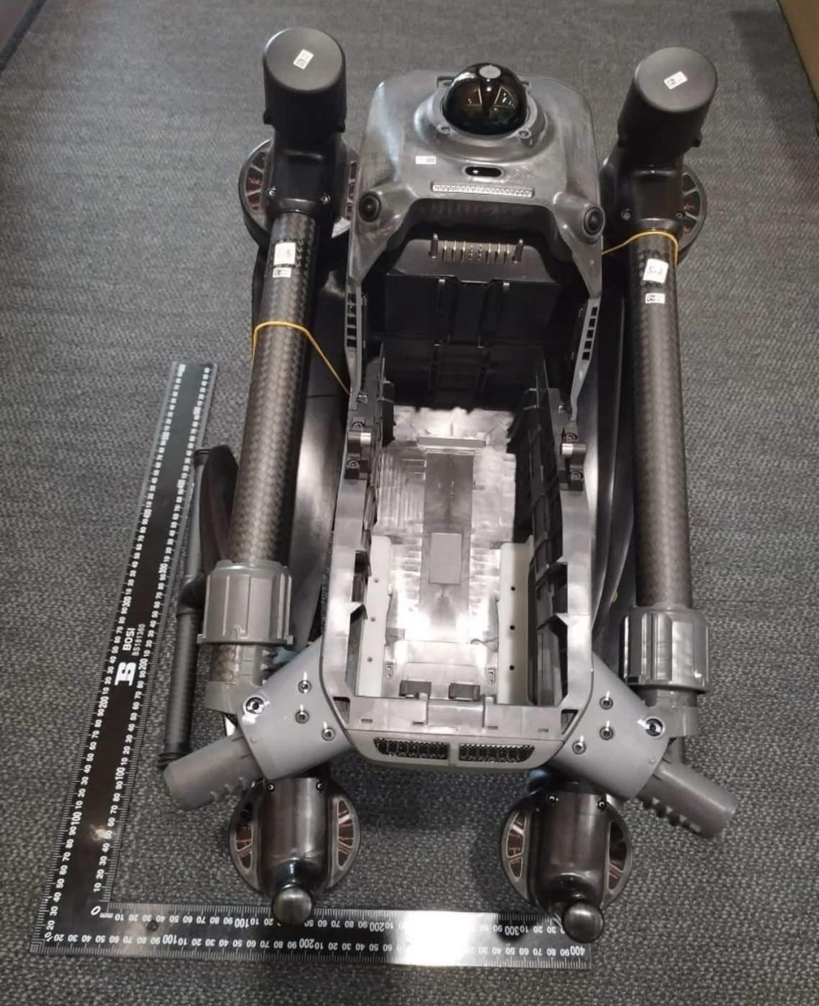 Overhead shot of the airframe beside a ruler, showing motors and battery bay.